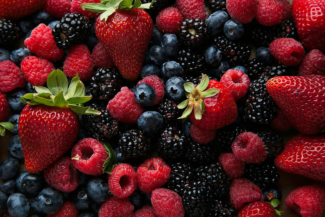 Strawberries and blueberries on a white ceramic plate