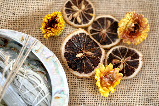Dried orange slices and dried flowers on a table beside a plate