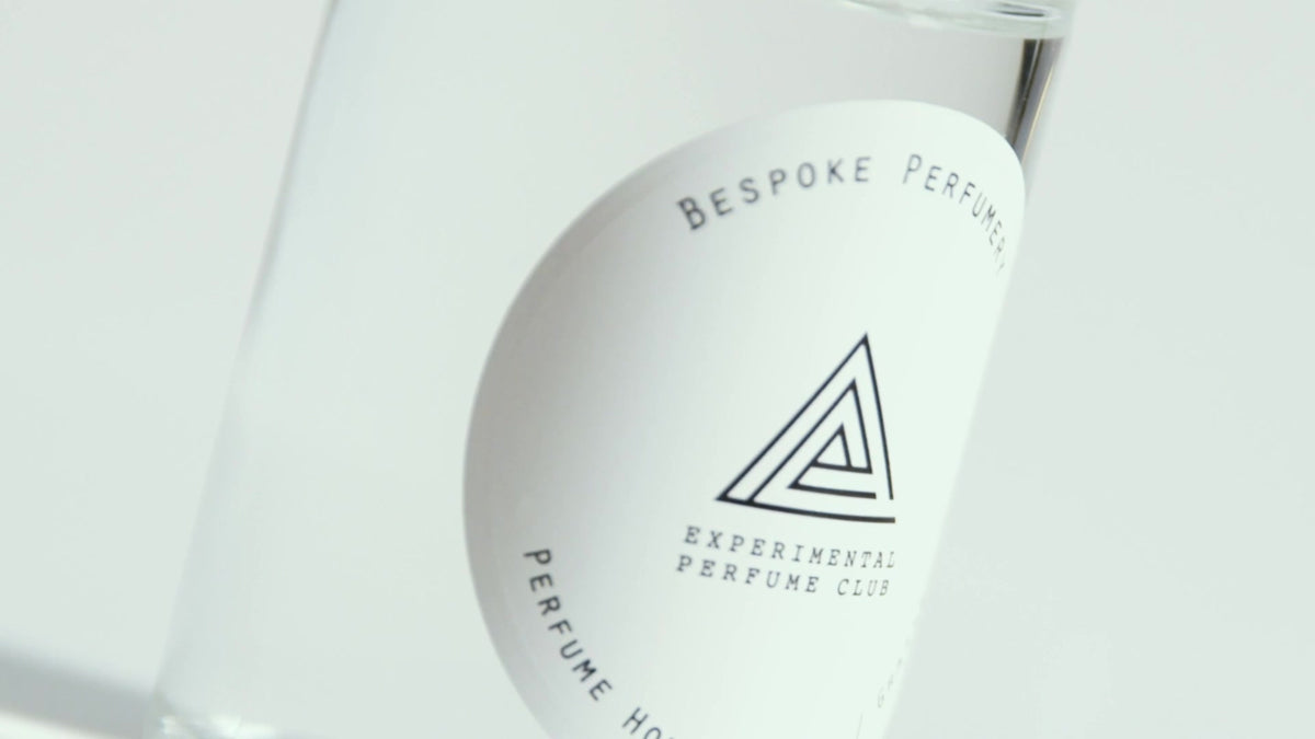 Hands blending a custom perfume and pouring it into an EPC bottle, London lab